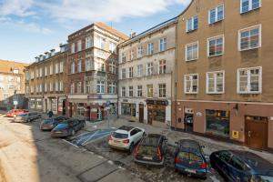 parking z samochodami zaparkowanymi przed budynkami w obiekcie Platinium Garncarska Old Town w Gdańsku