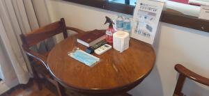 una mesa de madera con una botella de agua y un mando a distancia en A Place to Remember El Nido, en El Nido