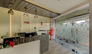 a lobby with a reception desk and a large window at Treebo Trend Glassotel in Kolkata