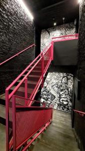 a red staircase in a room with a wall with graffiti at Silicate Ben Yehuda - Smart Hotel by Loginn Tel Aviv in Tel Aviv
