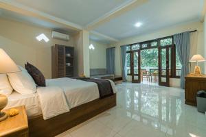 a bedroom with a bed and a living room at Vaneka Garden House in Ubud