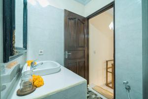 a white bathroom with a sink and a mirror at Vaneka Garden House in Ubud