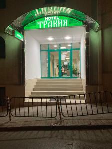 a hotel entrance with a bench in front of a building at Хотел Тракия in Haskovo