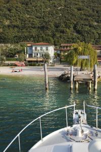 una barca è ormeggiata in un molo in acqua di Albergo San Remo a Malcesine