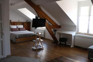 ein Schlafzimmer mit einem Bett und einem Schreibtisch im Dachgeschoss in der Unterkunft Le Studio de Sophie in Vendôme