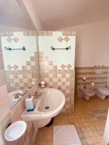 La salle de bains est pourvue d'un lavabo et de toilettes. dans l'établissement B&B La Pitraia, à Sant Antonio Di Gallura