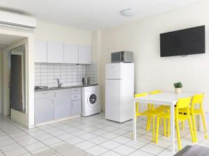 uma cozinha com cadeiras amarelas e um frigorífico branco em Apartament - Lev Eilat 8 em Eilat