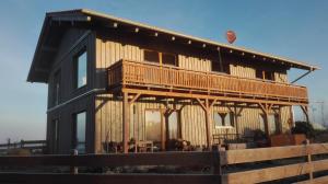 a wooden house with a deck and a hot air balloon at Heimat-Raum in Bad Bayersoien