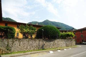 a stone wall next to a street with a building at Il Vaticano del lago d Idro in Crone