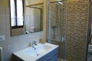 a bathroom with a sink and a shower with a mirror at Il Vaticano del lago d Idro in Crone +7 photos