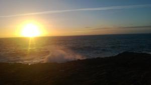 a wave in the ocean with the setting sun at Le Churchill Hôtel & Spa in Carnac