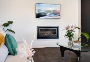a living room with a couch and a fireplace at Homestead Retreat - 2 Bedroom - Lake View in Queenstown