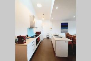 a kitchen with white cabinets and a counter top at Modern 3 bedroom apartment, beach, surf & shops in Cape Woolamai