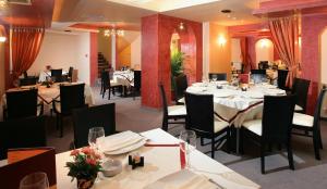 ein Restaurant mit weißen Tischen und Stühlen und Tischsuche in der Unterkunft Riverside Family Hotel in Yambol