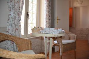 Zimmer mit einem Tisch, Stühlen und einem Fenster in der Unterkunft Domus de Carrera in Golfo Aranci