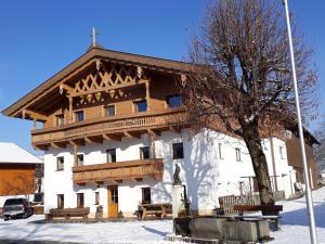 un gran edificio blanco con techo de madera en Ferienwohnungen Tischlerhof, en Ebbs