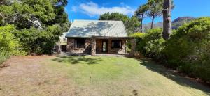 a small stone house with a yard at Houtkapperspoort Mountain Cottages in Cape Town +137 photos