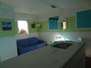 サン・ラファエルにあるAppartement Promenade des Bainsのリビングルーム(青いソファ付)、キッチン