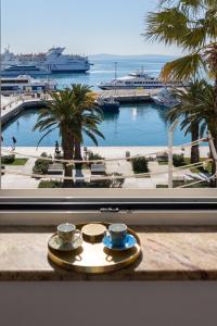 - une table avec deux tasses et une vue sur le port dans l'établissement Apartments Riva Lucija, à Split
