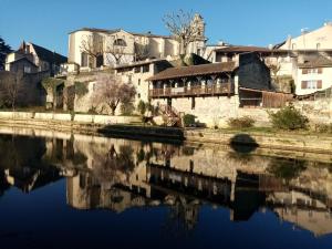 an old building next to a body of water at Les Terrasses du petit Nérac in Nérac