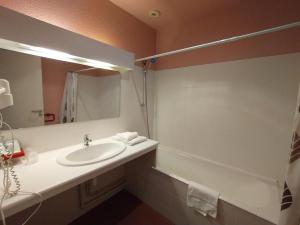 a bathroom with a sink and a mirror and a tub at Les Terrasses du petit Nérac in Nérac +19 photos