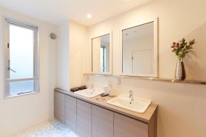 a bathroom with two sinks and two mirrors at Turn Table in Tokyo