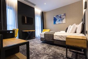a hotel room with a bed and a tv at Hugo Hotel in Satu Mare