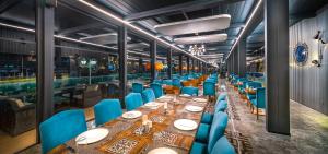 a dining room with a long table and blue chairs at Grand Mercure Ankara in Ankara