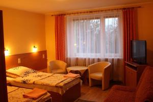 a hotel room with two beds and a television at Zajazd Jagnar in Trzcianka