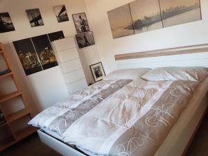 1 cama en un dormitorio con cuadros en la pared en Neuwertige 3 ½ Zimmer-Wohnung in Zillis/Andeer, en Zillis 32 fotos más