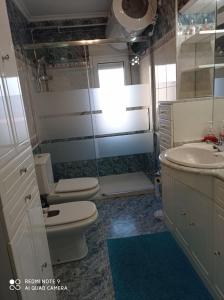 a bathroom with a toilet and a sink and a mirror at Bermejo Apartamento in Candás
