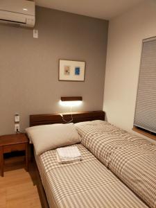 ein Schlafzimmer mit 2 Betten, einem Tisch und einer Lampe in der Unterkunft Deer hostel- - 外国人向け - 日本人予約不可 in Nara