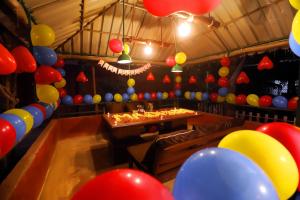 a party room with colorful balloons and a table at Pali Village Resort in Mire +84 photos