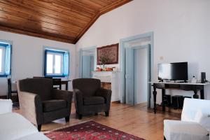 ein Wohnzimmer mit 2 Stühlen und einem Klavier in der Unterkunft Azoia 10 - Casas de Campo & Hostel in Azoia de Baixo