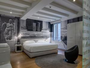 um quarto com uma cama branca e uma cadeira preta em Lords of Verona Luxury Apartments em Verona