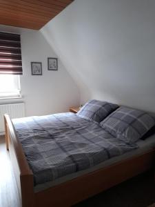 a bedroom with a bed with a blue and gray blanket at Ferienwohnung am Brunnen in Großheubach