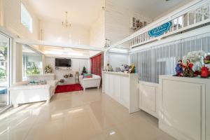 a large living room with white furniture and a large window at Banlomnow in Chiang Rai