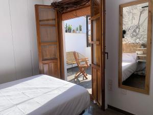 a bedroom with a bed and a mirror and a chair at ECO CENTER GRANATENSIS (ÁTICO-CATEDRAL) in Granada