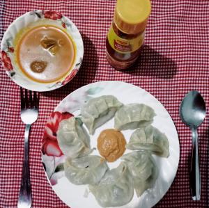 a plate of dumplings and a cup of coffee at Madys view -Aaple Ghar in Darjeeling