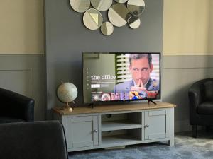 a flat screen tv sitting on a stand in a living room at Tudors in Chelmsford