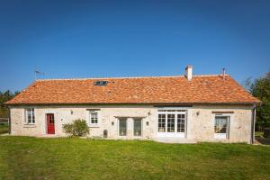 a house with an orange roof on a green field at Longère PROCHE LOCHES in Ciran