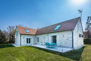 a white building with a patio in the yard at Longère PROCHE LOCHES in Ciran