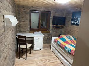1 dormitorio con escritorio, 1 cama y espejo en Ubytovanie v prírode, en Čaka