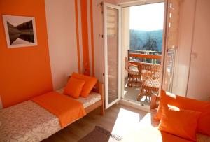 una camera da letto con pareti arancioni, un letto e un balcone di Biserna Dolina Uvac a Sjenica