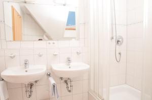 a white bathroom with two sinks and a shower at Gasthaus Kranz Bonndorf in Bonndorf im Schwarzwald