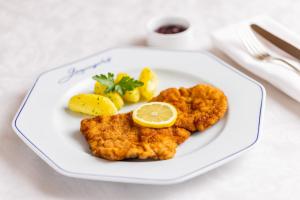 a plate of food with fish and lemon on a table at Hotel Gaspingerhof in Gerlos