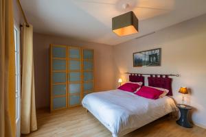 a bedroom with a large bed with red pillows at Longère PROCHE LOCHES in Ciran