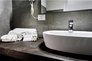 
a bathroom with a sink, toilet and bath tub at L'Essenza Hotel in Olbia
