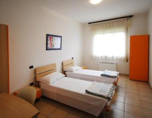 Cette chambre comprend 2 lits et une fenêtre. dans l'établissement Rifugio Natura Delta Po, à San Rocco