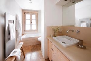 ein Badezimmer mit einem Waschbecken, einem WC und einem Spiegel in der Unterkunft Chalet Debussy - Our elegant farmhouse in Montriond